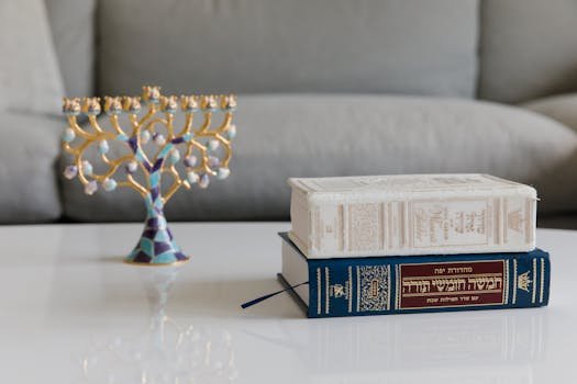 Artistic menorah next to religious texts. Perfect for cultural and symbolic image collection.
